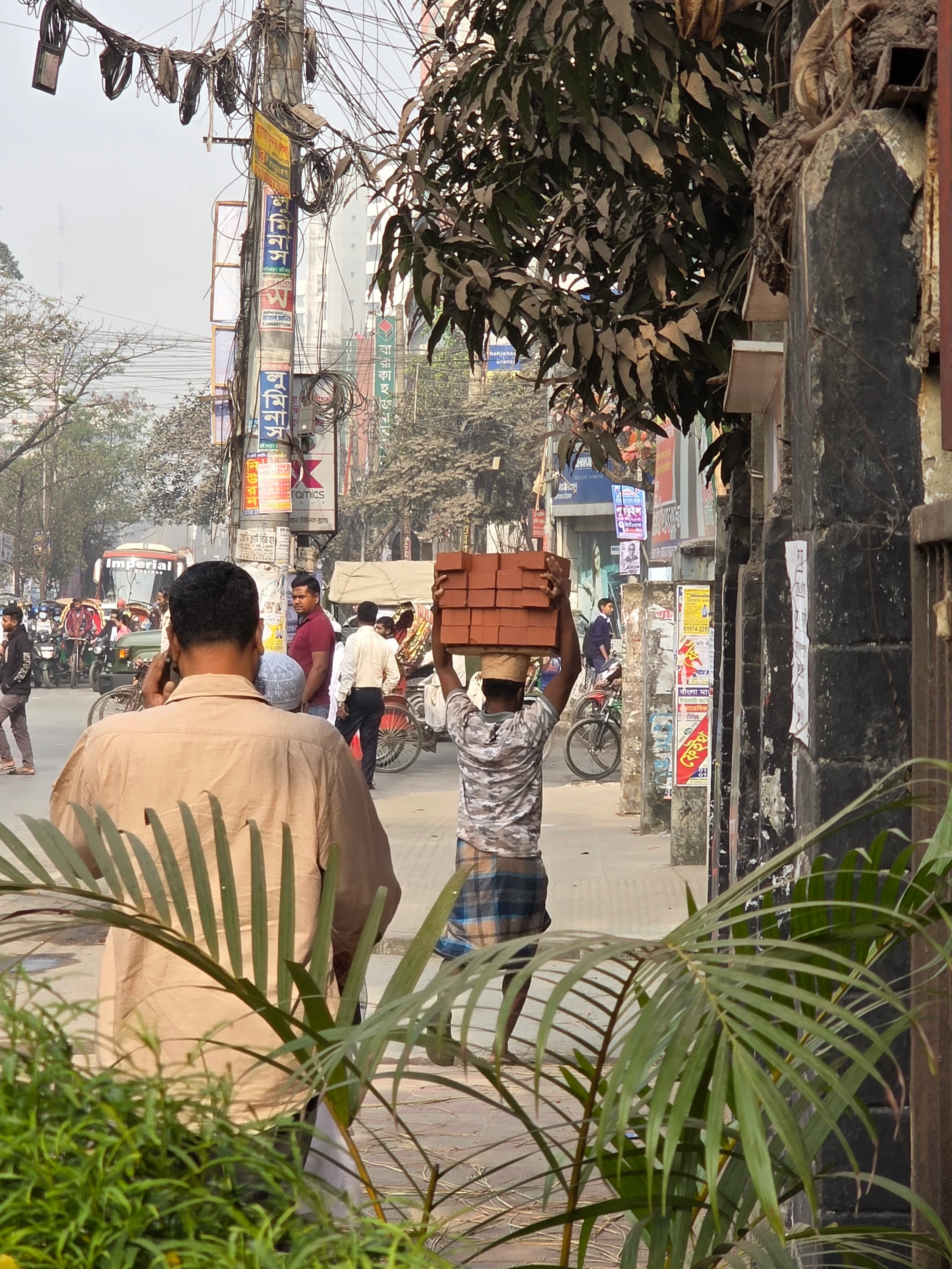 Dhaka – ulica, mężczyzna niesie cegły na głowie
